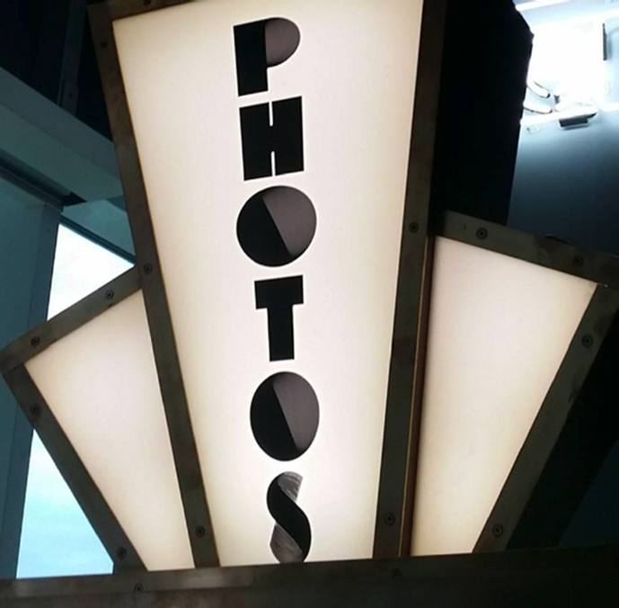 Close-up of the illuminated art deco PHOTOS sign