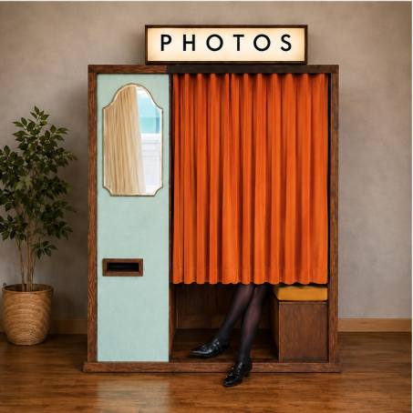 The Watson booth, in pale blue and timber with an orange curtain and a lit PHOTOS sign
